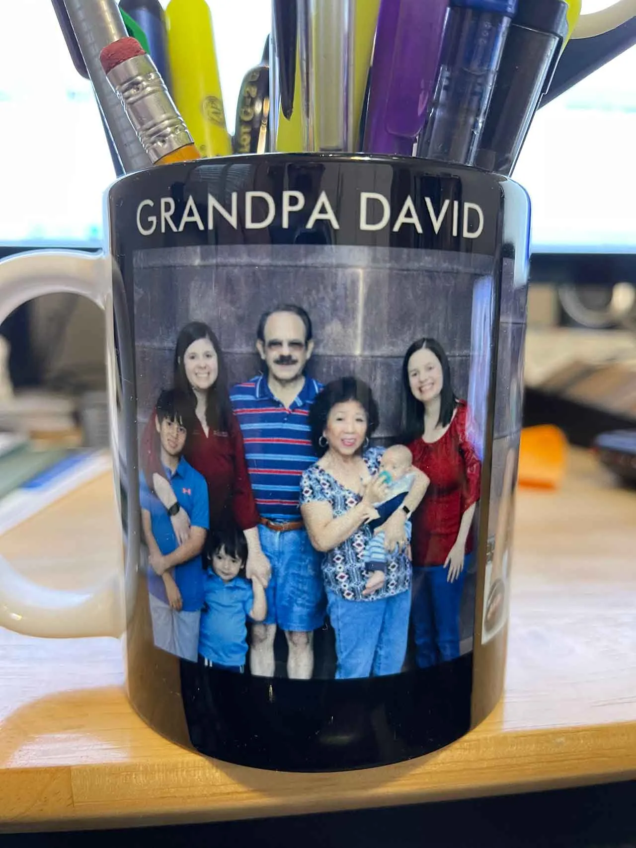 A mug reading Grandpa David with family photos