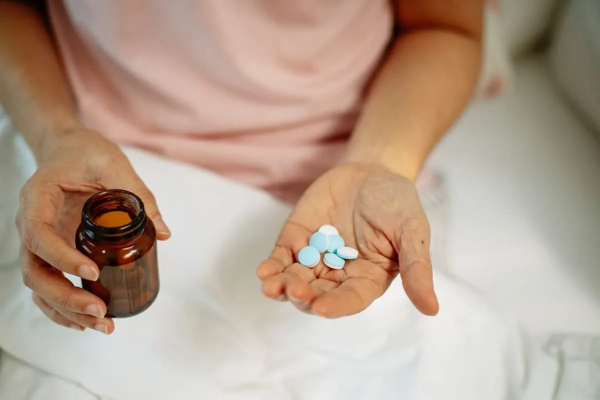 A man holding a bottle of pills, trying to decide whether or not to take hydroxyzine for anxiety.